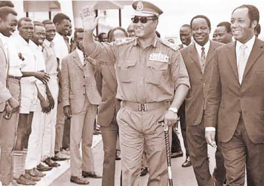 President Jafer Numeiry of Sudan waves to Sudanese students living in Kenya during a stop-over in Nairobi from Somalia on July 12, 1972. He was received by Foreign Minister Njoroge Mungai (right) and Commerce and Industry Minister Julius Gikonyo Kiano (partly hidden behind Gen Numeiry).