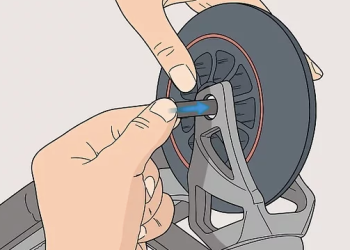 Hands replacing a scooter wheel axle during a wheel change on a kick scooter.