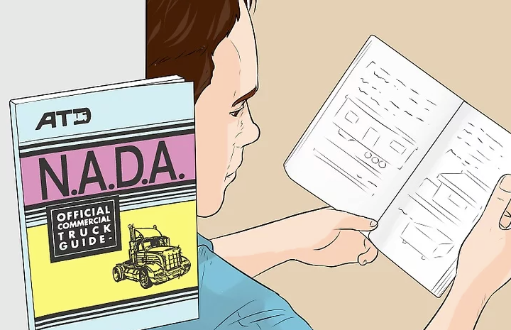 Person reading a mobile home valuation guide alongside the N.A.D.A. official commercial truck guide to estimate value.