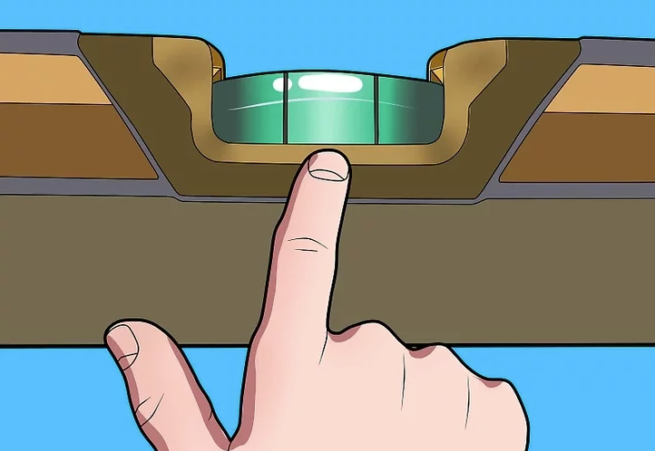 Person using a bubble level tool to check alignment while leveling a mobile home.