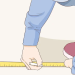 Illustration of a person using a tape measure and pencil to mark measurements on the floor for a project.