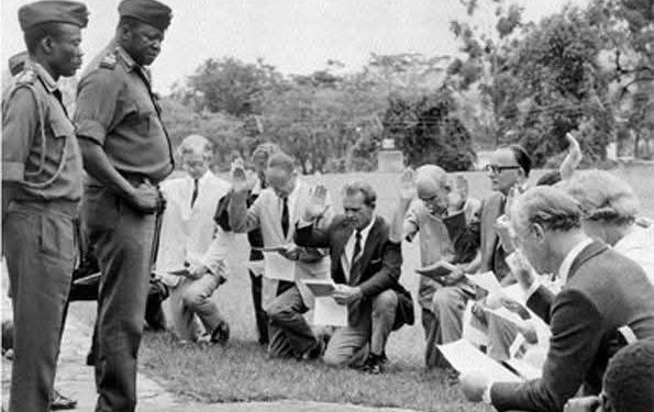 British expatriates kneel before Ugandan President Idi Amin during a citizenship oath ceremony at State House, Entebbe, September 1975.