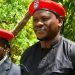 Kenyan activists Bob Njagi and Nicholas Oyoo wearing red berets during a political event in Uganda.