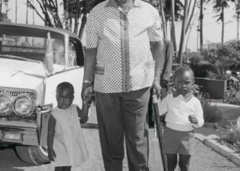 Historic image of Jomo Kenyatta standing with his children Uhuru Kenyatta and Nyokabi during Kenya’s early independence years.